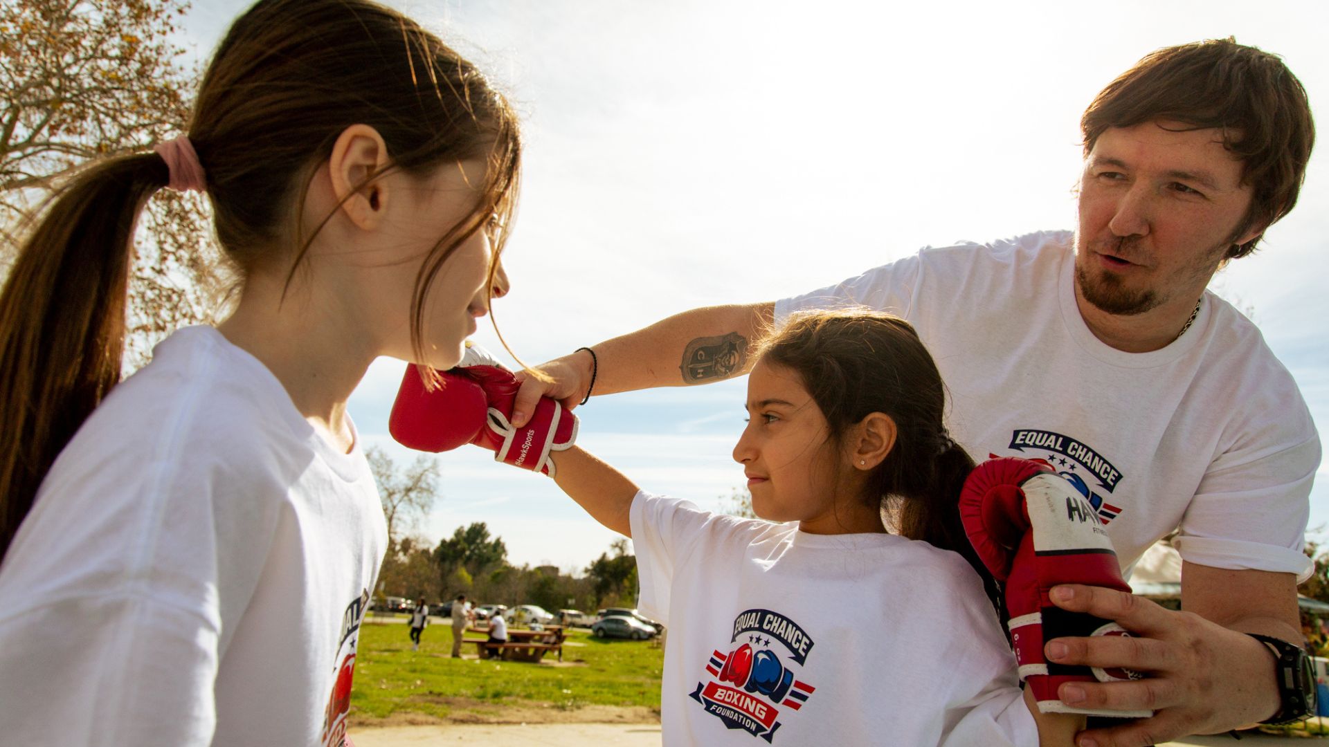 Why Coaches Matter More Than Motivation for At-Risk Youth: A Parent’s Guide to Real Mentorship girls in gloves empowering young women through sport